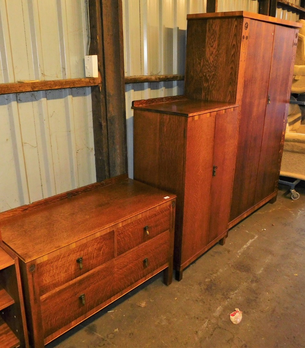 An early 20thC harlequin oak bedroom suite, comprising two door wardrobe and dressing chest, and an