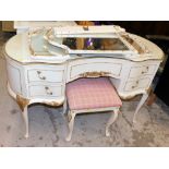 A mirror back kidney shaped dressing table, with associated stool. The upholstery in this lot does