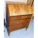 A mid century walnut and mahogany small bureau, the fall enclosing a fitted interior above three dra