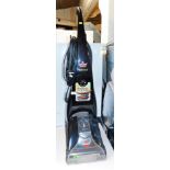 A Bissell Proheat upright carpet cleaner.