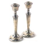 A pair of Elizabeth II silver candlesticks, each with urn dish holders, tapering cylindrical stems a