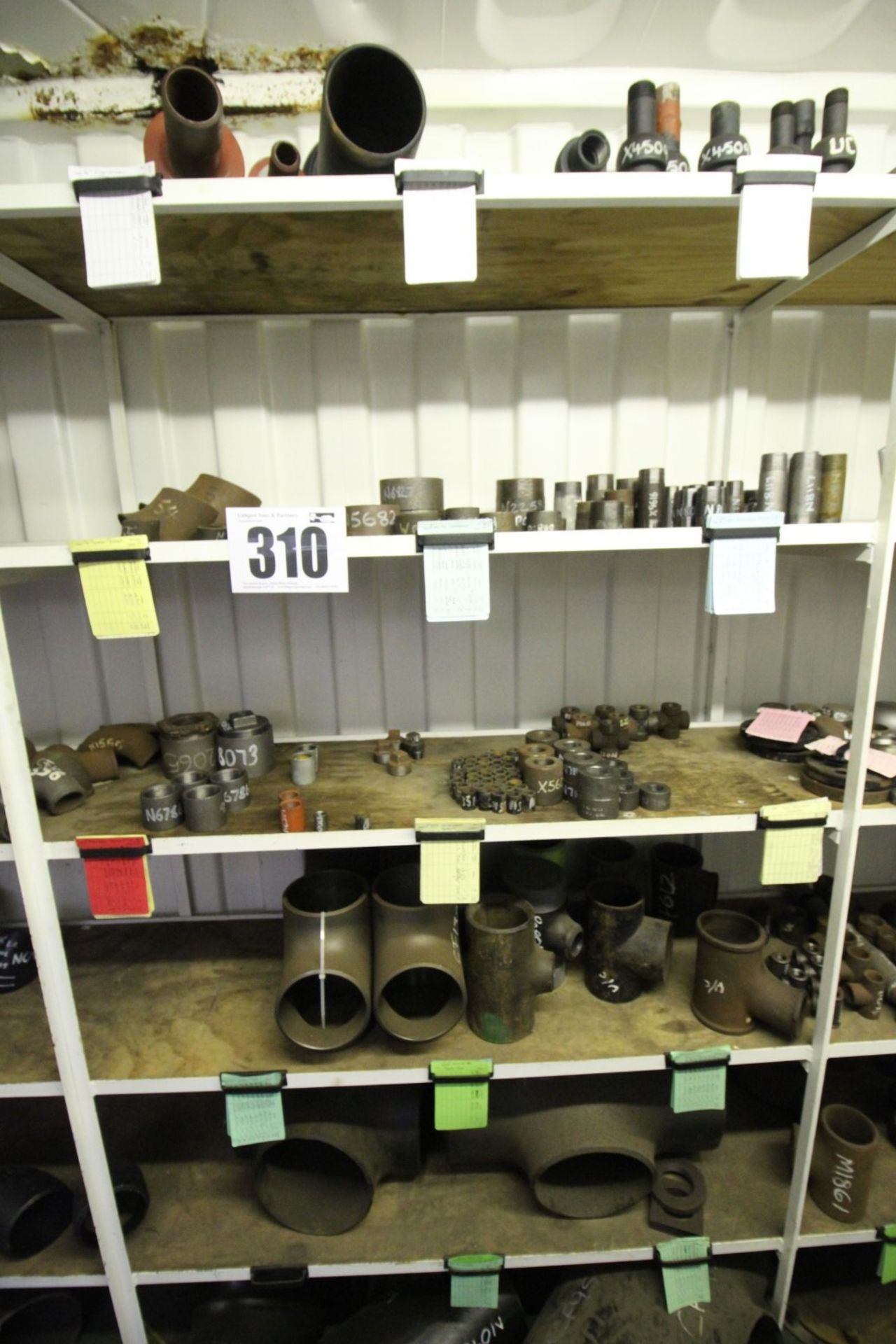 CONTENTS OF 5 SHELVES OF SECTION OF RACK PLUS FLOOR OF FERROUS PIPE FLANGES