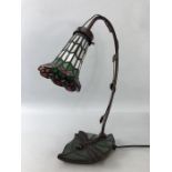 Tiffany style table lamp with a dragonfly and leaf base