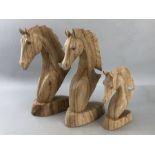 Three wooden carved horses heads the largest approx 30cm