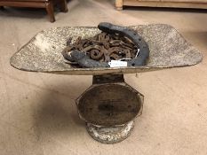 Vintage weighing scales currently weighing a large selection of horse shoes, some for a unicorn