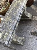 Two pedestal well-weathered garden bench