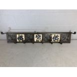 Metal coat rack with tiled decoration, scrollwork panels and rack over, approx 138cm x 23cm