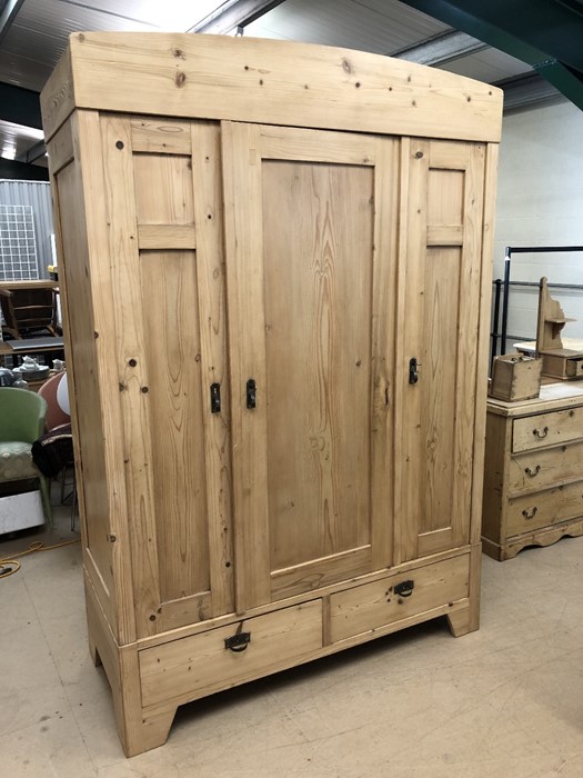 Large pine wardrobe with hanging and shelving space and two drawers to base, approx 140cm wide x