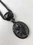 Victorian 3.5" Whitby Jet Pendant hung from a long velvet Ribbon. Main Oval drop approx 5.3cm