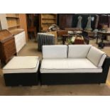 Small black garden sofa with white cushions and matching low table with either glass top or cushion