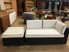 Small black garden sofa with white cushions and matching low table with either glass top or cushion