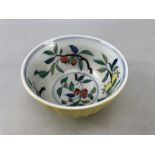 Yellow Chinese bowl with colourful fruit pattern to inside.