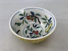 Yellow Chinese bowl with colourful fruit pattern to inside.