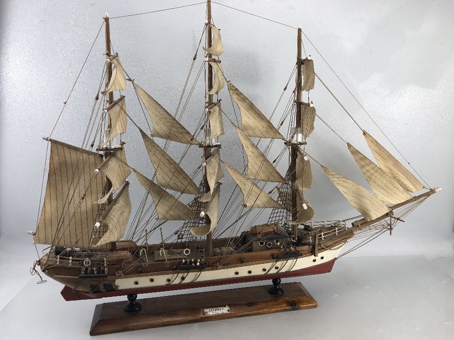 Wooden scale model of a three mast clipper 'Siglo XIX' displayed on a plinth. Length approx 85cm