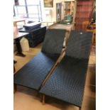 Pair of black woven garden loungers on wooden bases