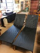 Pair of black woven garden loungers on wooden bases