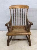 Large bobbin turned carver chair with cane seat and shaped arms, approx 103cm tall at back
