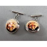 A pair of silver and enamel fox cufflinks