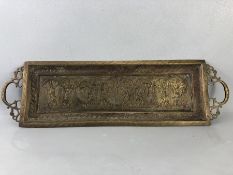 Oblong brass embossed tray with remnants of original colour pigments, two handles, depicting