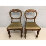 Pair of Victorian pine balloon backed chairs with turned front legs on original castors