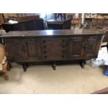 Dark wood sideboard with central flight of four drawers and carved panelled cupboards, approx