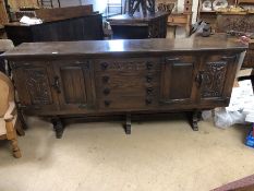 Dark wood sideboard with central flight of four drawers and carved panelled cupboards, approx