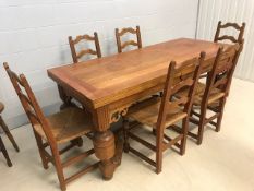 Solid wood dining table in the refectory style with substantial turned legs and carved detailing,