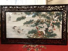 Large painted porcelain plaque depicting cranes with Chinese writing and character marks, mounted in