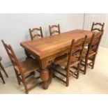 Solid wood dining table in the refectory style with substantial turned legs and carved detailing,