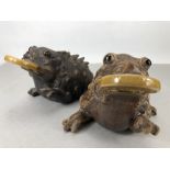 Two decorative Chinese toads with counters in their mouths