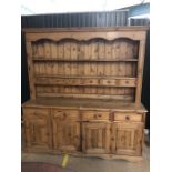 Large pine kitchen dresser with multiple drawers and cupboards under, approx 184cm x 48cm x 193cm