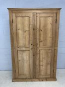 Antique pine two door wardrobe with hanging section to left and shelving to right