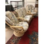 Cane conservatory suite comprising two seater sofa and a pair of swivel armchairs