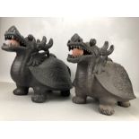 Pair of black painted pottery Chinese dragons with ceramic balls in mouths and turtle handled lids