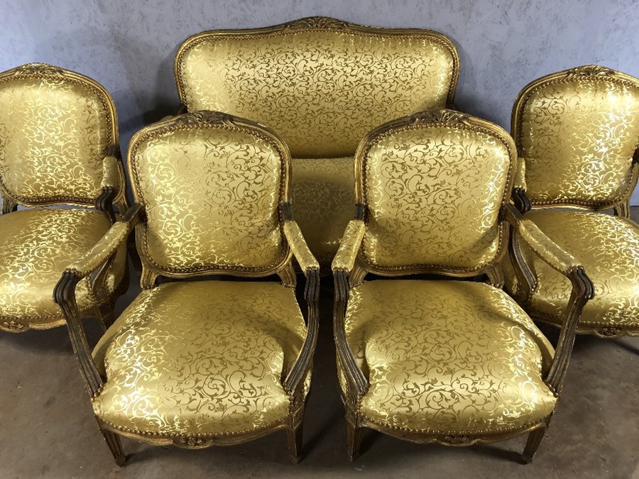 Five piece suite to include two seater sofa and four armchairs with wood and gilt frames and gold