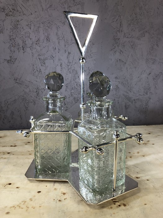 Dresser style silver plated three decanter tantalus, decanters approx 23cm in height