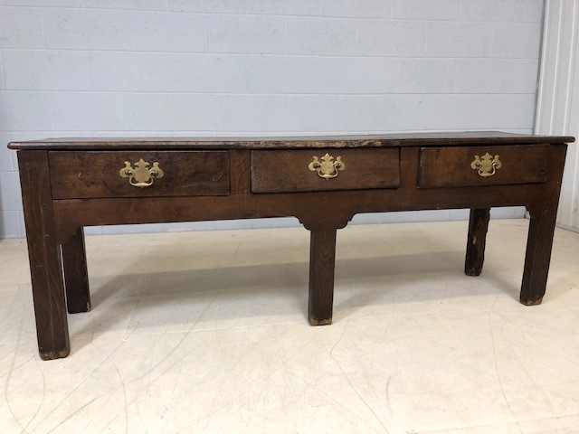 18th Century low oak console / table with three drawers and brass handles, approx 170cm x 40cm x