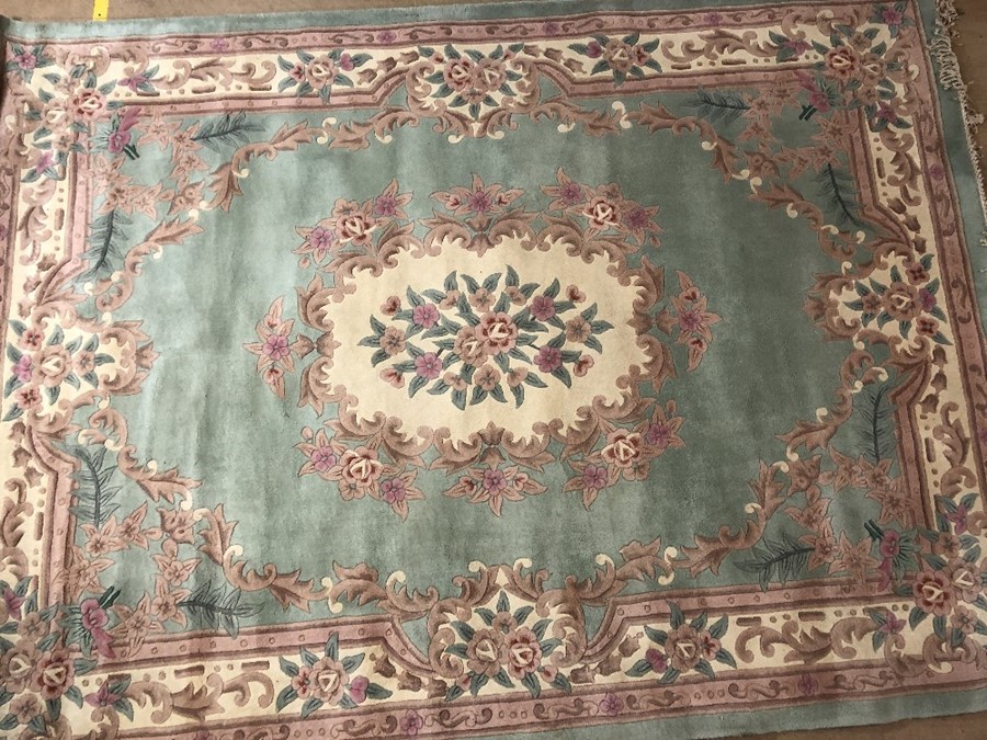 Large Chinese Oriental wool pale green ground rug with floral design, approx 330cm x 244cm