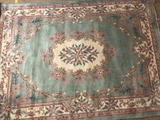 Large Chinese Oriental wool pale green ground rug with floral design, approx 330cm x 244cm