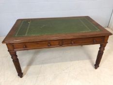 Writing desk / table with green inlaid leather top on carved legs with two drawers, approx 137cm x