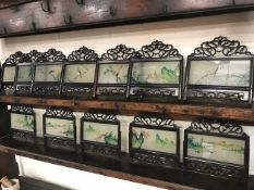 Collection of hand painted Chinese glass screens depicting birds in pierced wooden frames,