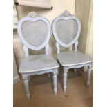 Two carved painted rattan backed heart shaped decorative chairs