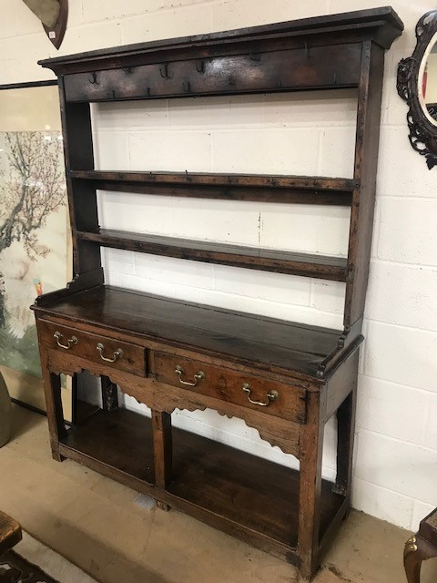 Oak dresser with original brass fittings, two drawers and shelves below and shelves and hooks