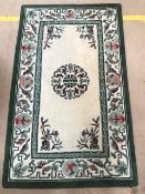 Oriental woollen cream ground rug with green oriental design, approx 150cm x 92cm