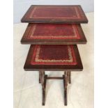 Nest of three red leather-topped side tables