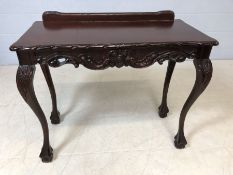 Modern carved occasional table on ball and claw feet with upstand, approx 94cm x 46cm x 76cm tall