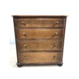 Dark wood chest of drawers with four drawers and carved detailing on bun feet