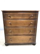 Dark wood chest of drawers with four drawers and carved detailing on bun feet