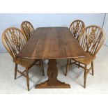 Refectory style dining table, possibly Ercol, with four wheel back dining chairs
