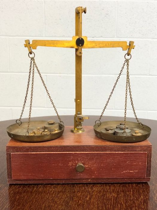 Set of Class B brass weighing scales on wooden box, with various weights